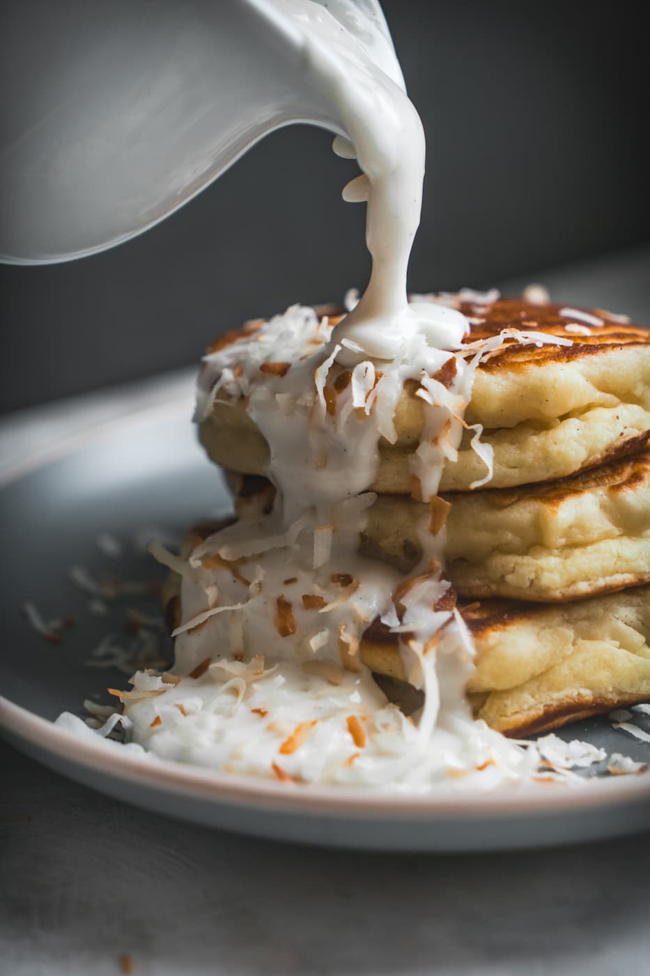 kelly-jean-TclQHtlkzRc-unsplash Fluffy Coconut Ricotta pancakes stack with haupia syrup being poured over them