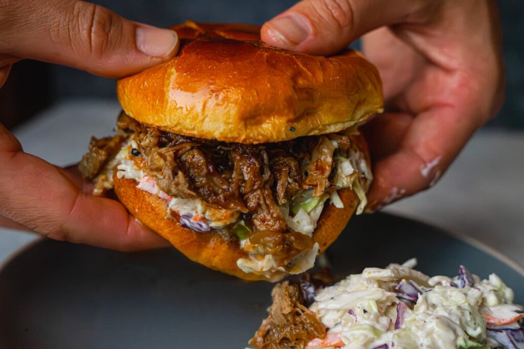 BBQ Pulled Pork served in a bun with coleslaw and pickles
